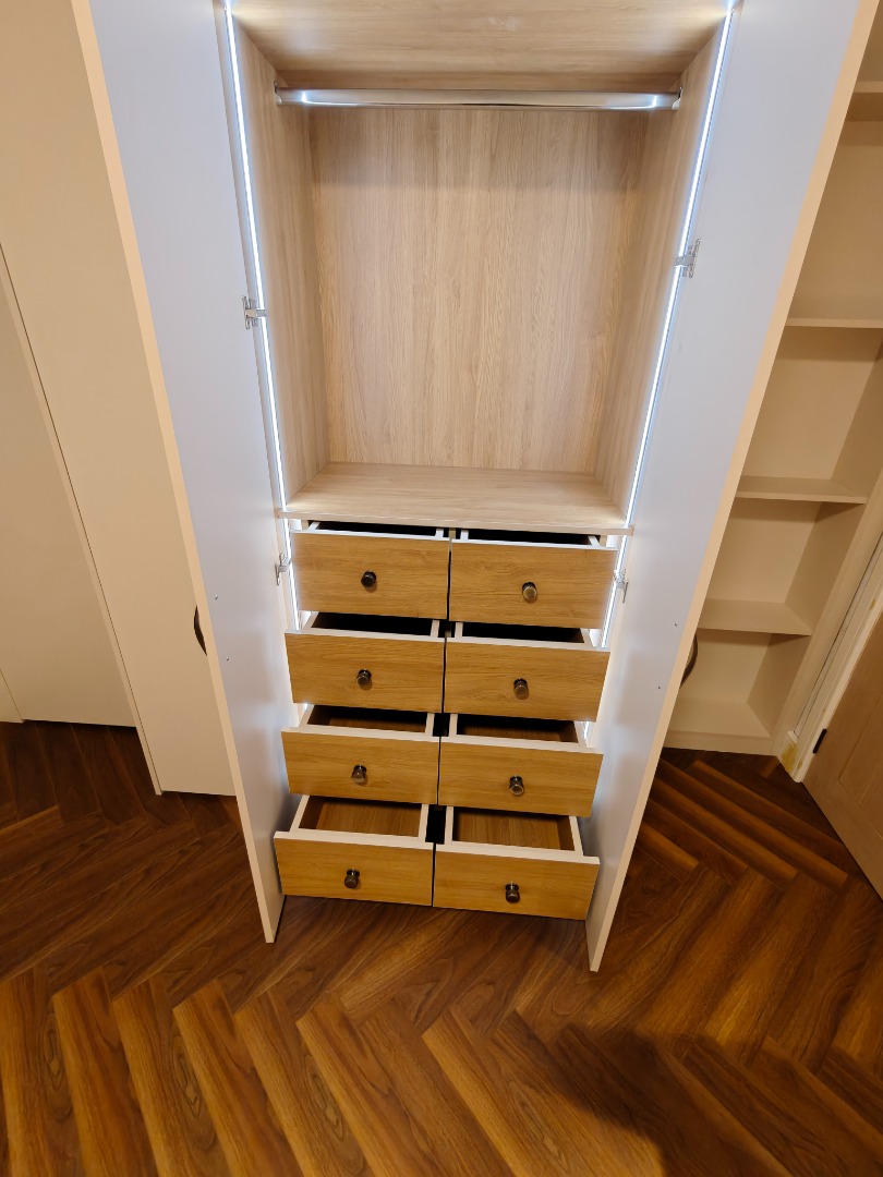 Fitted wardrobe interior with oak drawers and hanging rail