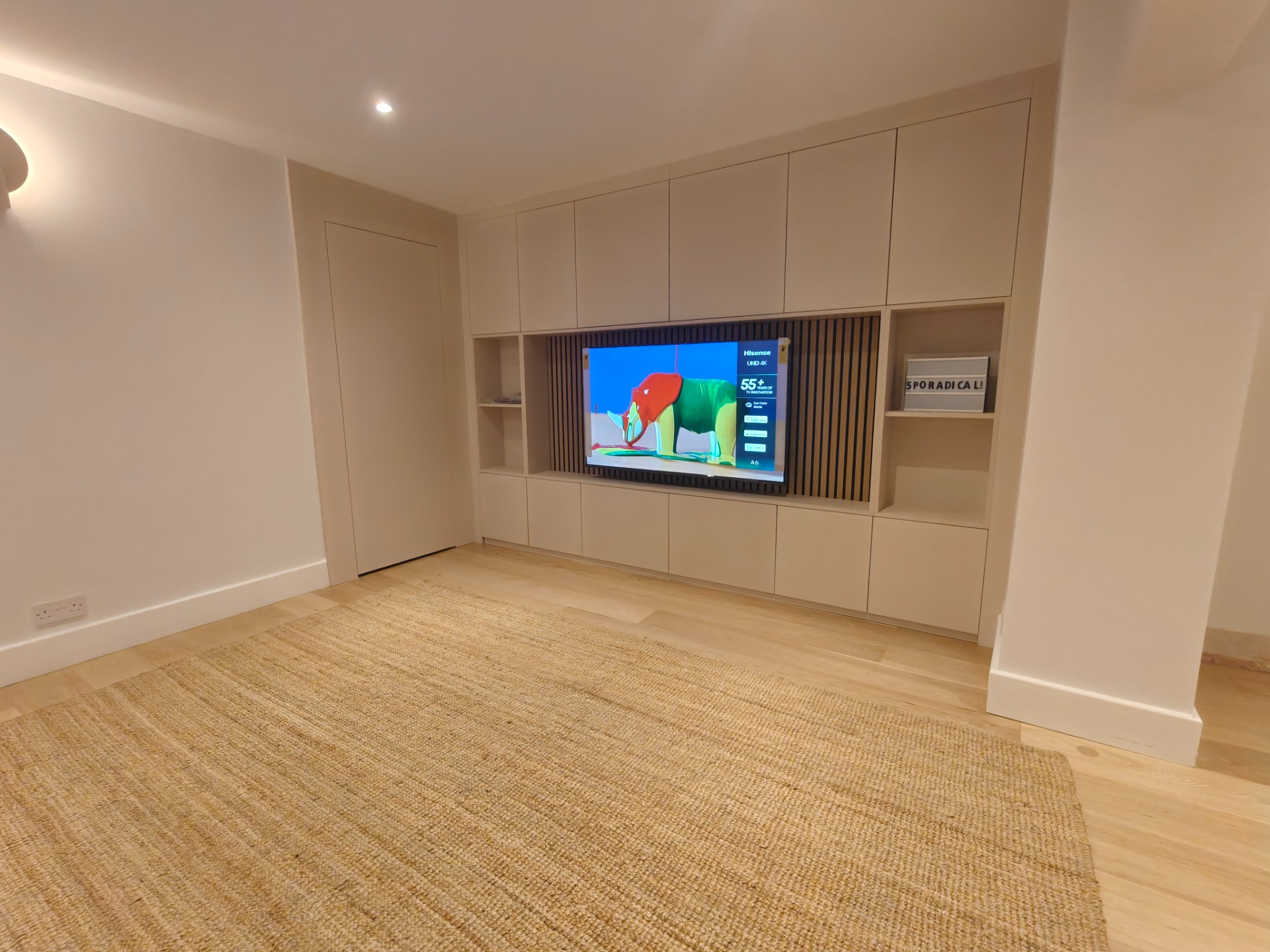 Built-in media wall with TV, slatted panel and cabinetry