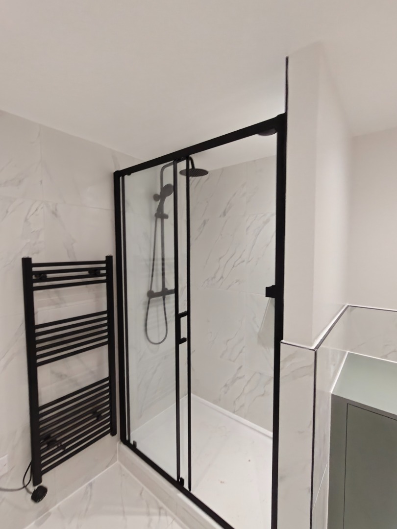 Bathroom with black-framed shower enclosure and marble tiling