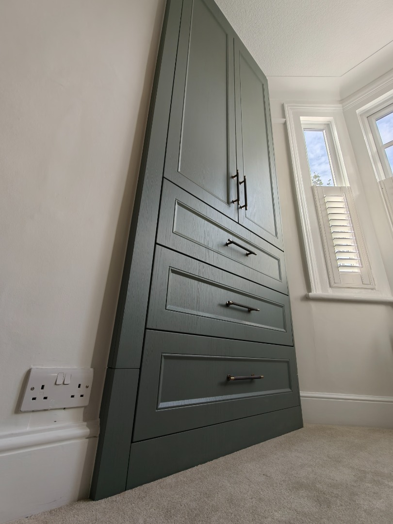 Green bespoke fitted wardrobe with drawers