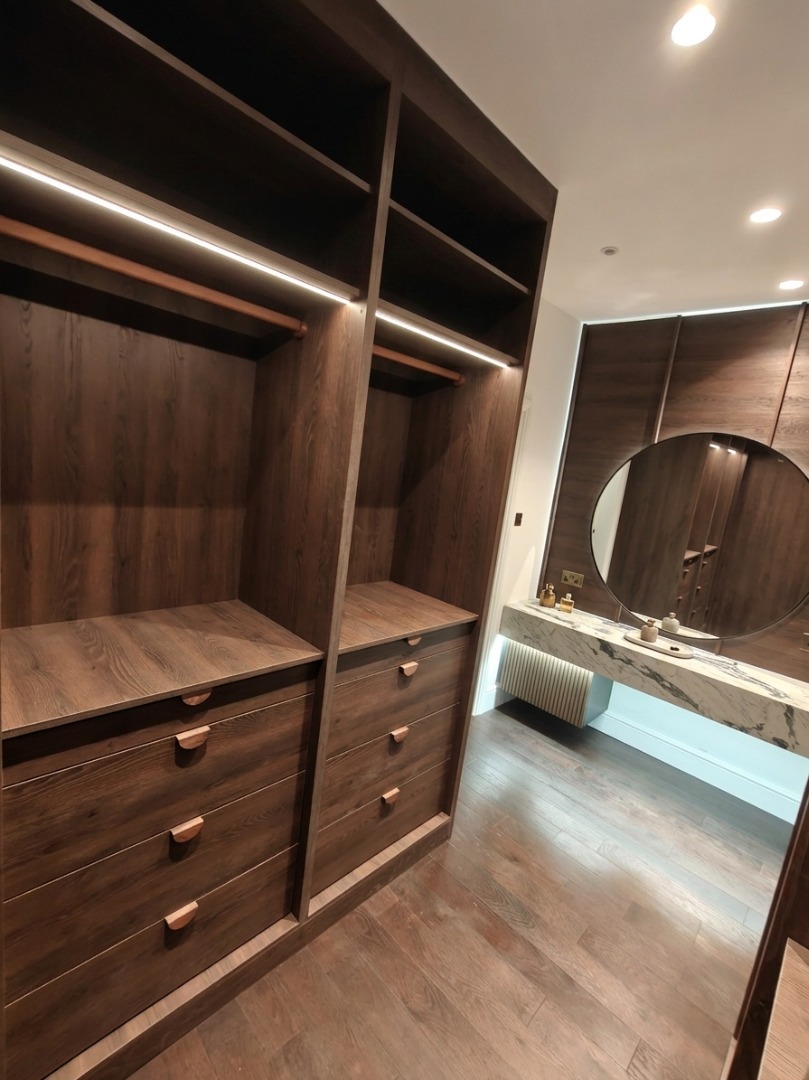 Walk-in wardrobe in dark oak with marble vanity